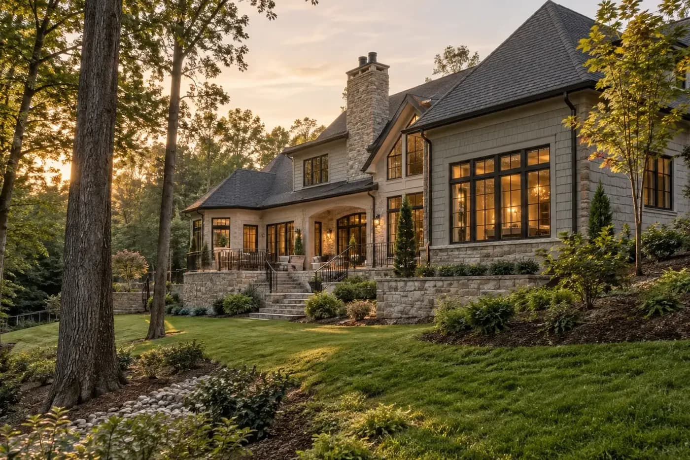 Illustrative luxury custom home stepped into a wooded grade with stable landscaping and a visible drainage path