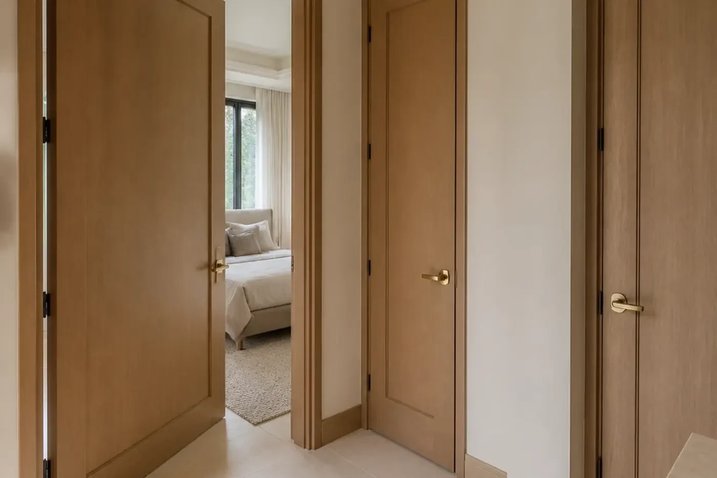 New custom-home bedroom vestibule with coordinated white-oak interior doors and clear circulation