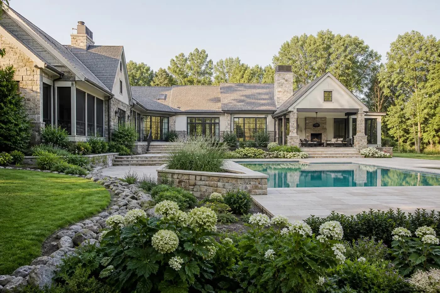 New Charlotte custom home and swimming pool coordinated with stone grade transitions, planted drainage, terraces, and a sloping rear garden