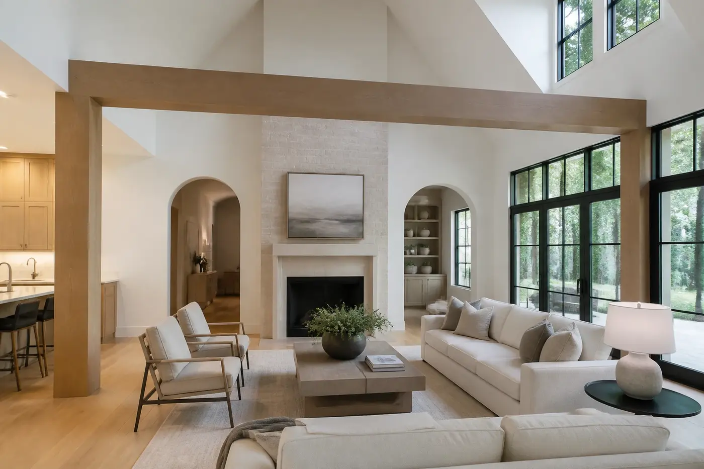 New Charlotte custom-home great room with a substantial timber beam, aligned supports, vaulted ceiling, and broad residential window wall