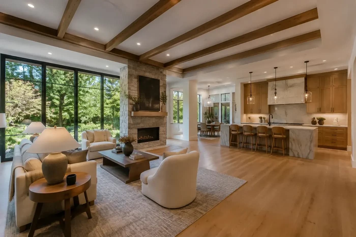 New Charlotte custom-home great room and kitchen with coordinated furniture, circulation, ceiling beams, lighting, windows, and fireplace